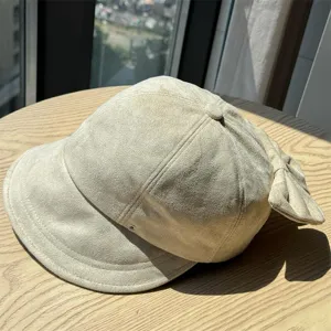 Beige suede newsboy hat detail view, featuring a cute back bow and vintage pleated design.