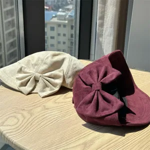 Close-up detail of vintage suede newsboy hats with elegant big bows for autumn style.