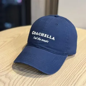 Detailed shot of dark blue cotton baseball cap featuring Coachella embroidery detail.