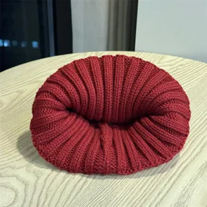 Detailed view of a cozy wine red knit beanie, perfect for keeping warm during autumn and winter.