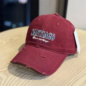 Detailed close-up of a stylish distressed red baseball cap featuring front embroidery.
