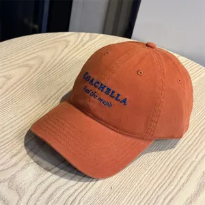 Detailed view of the orange cotton baseball cap featuring stylish blue embroidery text design.