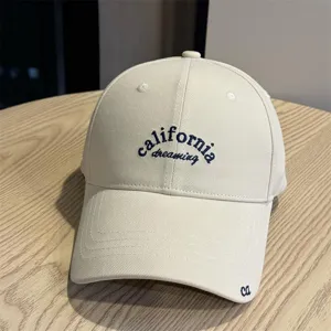 Close-up detail of stylish beige cotton baseball hat featuring unique embroidery design, soft crown.