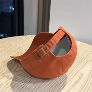 Oranger Baseballcap-Detail mit verstellbarem Metallschnallenriemen, weicher Freizeithut.