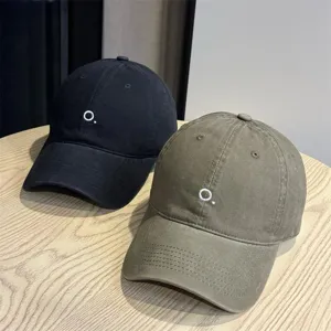 Detail shot of minimalist embroidered baseball caps showcasing soft brim and fine stitching texture.