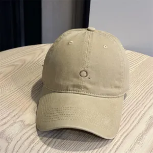 Detailed close-up shot of the casual beige baseball cap featuring neat embroidery on the soft crown.