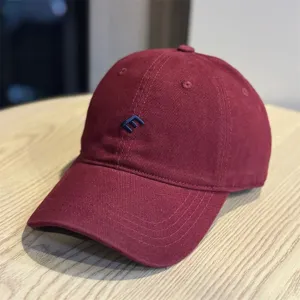 Detalle de gorra de béisbol burdeos, sombrero de algodón versátil con bordado azul elegante.