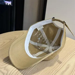 Detailed view of the khaki baseball cap interior, showing the soft crown and inner lining text.