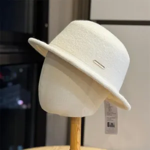 Detailed view of the elegant wool bucket hat, featuring a stylish metal logo and soft fabric.
