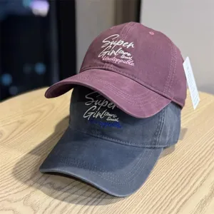 Detail view of casual couple baseball cap with stylish English embroidery and wide brim.