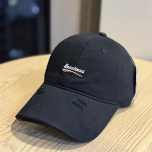 Washed black baseball cap with front letter embroidery and distressed brim, casual street style.