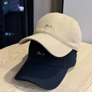 Detail view of casual embroidered baseball cap soft top unisex minimalist sun hat autumn style.