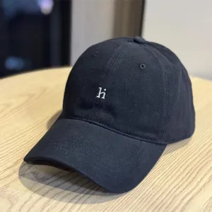 Black washed cotton baseball cap detail, featuring white embroidered letter hi on front.