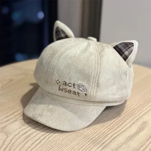 Close-up detail of cute cat ear beret hat with adorable embroidery and plaid inner ears.