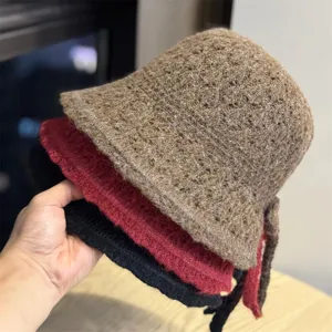 Vista dettagliata del morbido cappello a secchiello in maglia con nodo a fiocco decorativo.