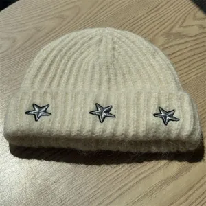 Korean style knitted beanie with star embroidery for warm autumn and winter casual wear.