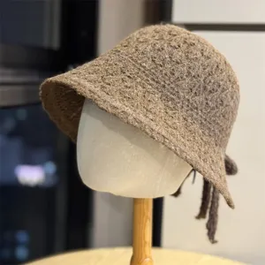 Dettaglio cappello secchiello in maglia marrone con lana e nastro posteriore.