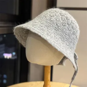 Primo piano di un cappello bucket in maglia soffice grigia con grazioso nastro sul retro.