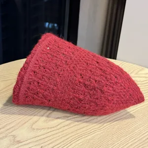 Primo piano dettagliato del cappello da pescatore invernale in maglia rossa accogliente.