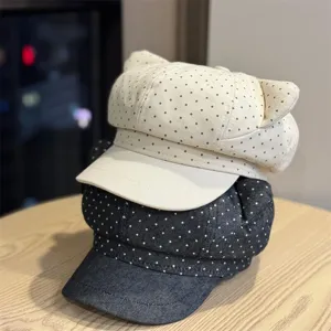 Detailed close-up of cute cat ear beret hats featuring polka dot design in beige and denim.