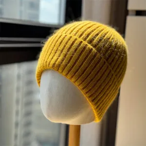 Primo piano dettagliato del morbido berretto in maglia a coste gialla, con trama in lana.