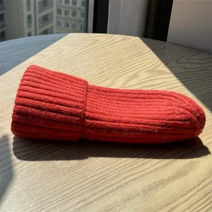 Dettaglio in primo piano del berretto invernale da donna in maglia rossa, risvolto morbido.