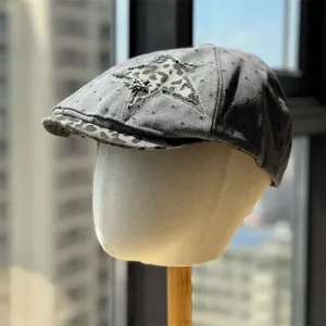 Grey denim newsboy cap with leopard star patch and metal charm, vintage style chic hat.