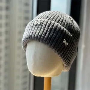 Grey knitted winter beanie hat featuring cute silver bow charms, cozy and warm headwear.