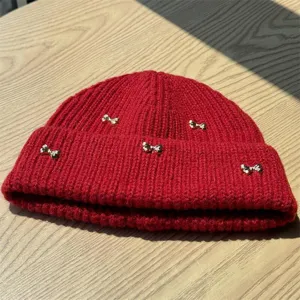 Red knit beanie for women winter cold weather outdoor wear cute gold bow detail soft cozy warm hat