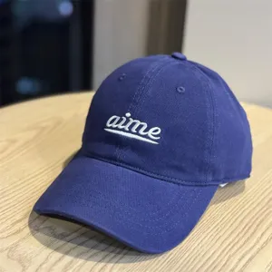 Blue cotton baseball cap with white embroidered letters, soft top and wide brim style.