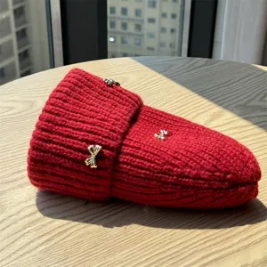 Detail view of a cozy red winter knit beanie hat featuring elegant gold bow charms for women.