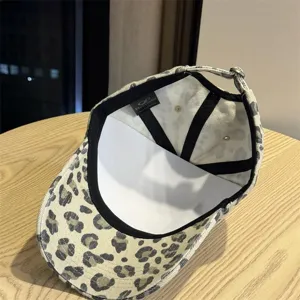 Dettaglio cappello da baseball leopardato con fodera interna e cinturino regolabile.