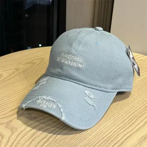 Detailed view of light blue distressed baseball cap with chic embroidery and curved brim design.