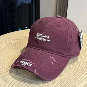Close-up detail of the vintage washed baseball cap featuring front embroidery and ripped brim.
