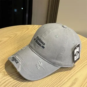 Grey distressed baseball cap with embroidered letters, casual sun hat for men and women.