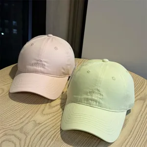 Gorra de béisbol coreana minimalista con letras bordadas, diseño suave, rosa y verde claro.