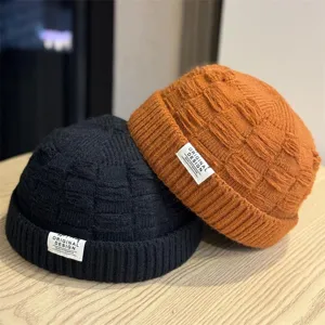 Gedetailleerd overzicht van casual gebreide docker mutsen in zwart en oranje met textuur.