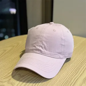 Vista detallada de gorra de béisbol de algodón morado claro con bordado frontal suave.