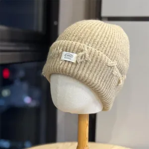 Detailed view of the knitted beanie hat showing textured ribbed knit and distressed ripped details.