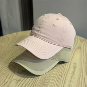 Vintage washed baseball cap with chic embroidery, casual streetwear style, pink and khaki.
