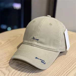 Detail view of the khaki cotton baseball cap featuring stylish letter embroidery and curved brim.