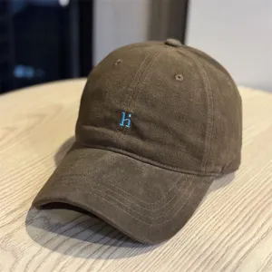 Close-up detail of the vintage washed cotton baseball cap featuring blue embroidered letter.