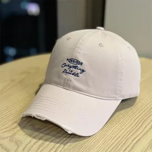 Detailed view of the stylish pink baseball cap with front embroidery and frayed brim.