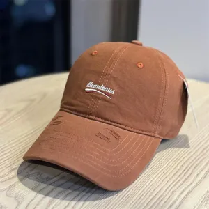 Brown washed cotton baseball cap with embroidered lettering and distressed brim for a stylish look.
