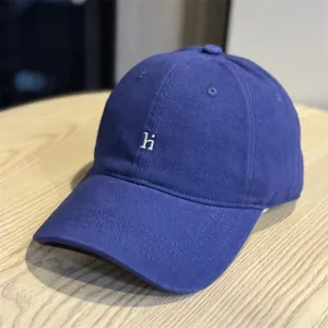 Close-up detail of the washed cotton baseball cap with embroidered letter hi, soft top.
