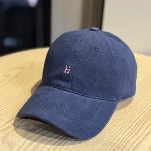 Vintage washed cotton baseball cap with pink embroidered hi letter, soft top design.