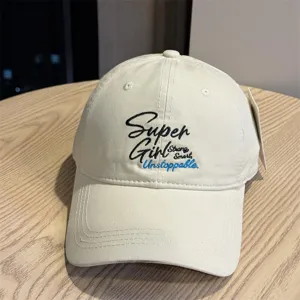 Close-up detail of beige cotton baseball cap featuring stylish English embroidery text.