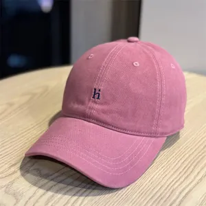 Pink washed cotton baseball cap featuring letter embroidery, soft top detail product view.