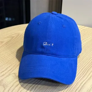 Detailed view of a royal blue casual baseball cap featuring white Don't embroidery.