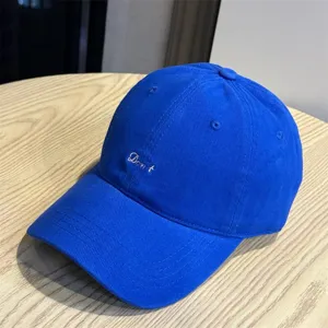 Blue baseball cap detail, casual soft top design with stylish front embroidery text accent.